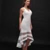 Woman wearing the Olia Midi Dress – a white sleeveless evening dress with a V-neckline and sheer striped high-low hem, ideal for elegant occasions.
