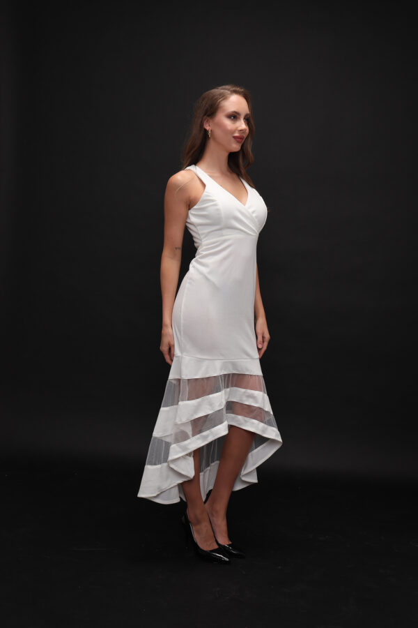 Woman wearing the Olia Midi Dress – a white sleeveless evening dress with a V-neckline and sheer striped high-low hem, ideal for elegant occasions.